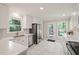 Updated kitchen with white cabinets, marble countertops, stainless appliances, and a door to the backyard at 4969 Royal Adelaide Way, Raleigh, NC 27604
