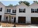 Newly constructed townhouse with white siding, black shutters, and attached garages at 51 Calluna Dr, Clayton, NC 27520