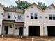 View of new construction townhomes featuring attached garages and an unfinished yard at 51 Calluna Dr, Clayton, NC 27520