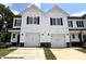 Charming townhome featuring a white exterior, a two-car garage and black trim at 51 Calluna Dr, Clayton, NC 27520