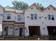 New townhomes show a modern design with multiple windows and attached garages in an active construction zone at 51 Calluna Dr, Clayton, NC 27520