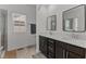 Bathroom featuring double sinks with mirrors, modern fixtures, and a window at 520 Austin View Blvd, Wake Forest, NC 27587