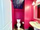 Vibrant half-bathroom with a unique tropical-themed ceiling, pink walls, and classic white fixtures at 520 Austin View Blvd, Wake Forest, NC 27587