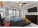Well-lit bedroom with ceiling fan, tray ceiling, large bed, and a dresser, offering style and comfort at 520 Austin View Blvd, Wake Forest, NC 27587
