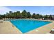 View of the community swimming pool with lounge chairs, trees and blue umbrellas at 520 Austin View Blvd, Wake Forest, NC 27587