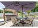 Backyard patio featuring an outdoor table with umbrella and hot tub, perfect for relaxation at 528 Brycewood Dr, Burlington, NC 27215