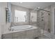 Bright bathroom with tiled flooring, standalone tub, and glass-enclosed shower at 528 Brycewood Dr, Burlington, NC 27215