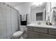 The bathroom features a toilet, shower with curtain, a gray vanity with quartz countertop, and stainless steel faucet at 528 Brycewood Dr, Burlington, NC 27215