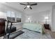 This bedroom features a treadmill, neutral walls, carpet, two side tables with lamps, and a ceiling fan at 528 Brycewood Dr, Burlington, NC 27215