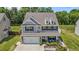 Charming two-story home with grey siding, a two-car garage, and a cozy front porch with outdoor seating at 528 Brycewood Dr, Burlington, NC 27215