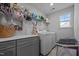 Well-lit laundry room featuring gray cabinets, countertops, and large capacity washer and dryer at 528 Brycewood Dr, Burlington, NC 27215