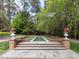 A backyard water feature is accented with stone and brick trim and potted flowers at 5420 Deer Forest Trl, Raleigh, NC 27614