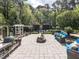 Backyard patio with fire pit, blue sofas and lush green landscaping at 5420 Deer Forest Trl, Raleigh, NC 27614