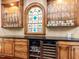 Custom bar area featuring wood cabinetry, glass shelving, and beverage refrigerators at 5420 Deer Forest Trl, Raleigh, NC 27614