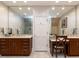 Dual sink bathroom with large mirrors, wood cabinets, and bright lighting at 5420 Deer Forest Trl, Raleigh, NC 27614