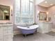 Elegant bathroom with a clawfoot tub under a stained-glass window and dual vanities at 5420 Deer Forest Trl, Raleigh, NC 27614