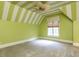 Bright bedroom with green walls, unique striped ceiling, fan, and a window with a view at 5420 Deer Forest Trl, Raleigh, NC 27614