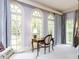 Bright bedroom featuring arched windows, a desk, and light purple walls at 5420 Deer Forest Trl, Raleigh, NC 27614