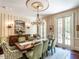 Elegant dining room featuring a chandelier, striped walls, and hardwood floors at 5420 Deer Forest Trl, Raleigh, NC 27614