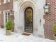Close up of the front door with stone archway, lantern sconces, and a decorative glass door at 5420 Deer Forest Trl, Raleigh, NC 27614
