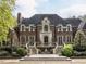 Beautiful brick home featuring a landscaped yard with symmetrical stairs leading to an arched doorway at 5420 Deer Forest Trl, Raleigh, NC 27614