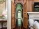 Elegant hallway with wood paneling and an arched doorway leading to a bright window at 5420 Deer Forest Trl, Raleigh, NC 27614