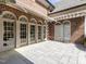 Brick home's backyard patio with four sets of french doors leading to a patterned stone terrace at 5420 Deer Forest Trl, Raleigh, NC 27614
