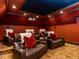 Luxurious theater room with plush seating, red walls, and a ceiling-mounted projector at 5420 Deer Forest Trl, Raleigh, NC 27614