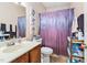 Bathroom with decorative shower curtain, oak cabinet sink, and a toilet at 6001 Winterpointe Ln # 102, Raleigh, NC 27606