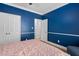 Comfortable bedroom featuring blue walls, trim detail and double door closet at 6001 Winterpointe Ln # 102, Raleigh, NC 27606