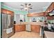 Spacious kitchen features stainless steel appliances, wood cabinets, and a breakfast bar looking into another room at 6001 Winterpointe Ln # 102, Raleigh, NC 27606