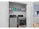 Laundry room with shelving and stainless steel washer and dryer units at 6001 Winterpointe Ln # 102, Raleigh, NC 27606