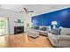 Bright living room featuring a fireplace, hardwood floors, and stylish furniture against a bold blue wall at 6001 Winterpointe Ln # 102, Raleigh, NC 27606