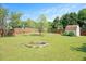 Grassy backyard showing a fire pit, storage shed, and wood fence providing privacy at 604 Sinewell Dr, Wake Forest, NC 27587