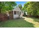 A serene backyard featuring a screened-in porch, a wooden fence, and lush green foliage at 604 Sinewell Dr, Wake Forest, NC 27587