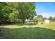 Expansive backyard with mature trees, a small storage shed, and a play area featuring a soccer goal at 604 Sinewell Dr, Wake Forest, NC 27587