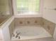 The soaking tub in this bathroom has tile accents and a window at 6673 Nc 96 W Hwy, Youngsville, NC 27596