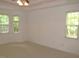 This bedroom features neutral carpet, base trim, ceiling fan, and three large windows for lots of light at 6673 Nc 96 W Hwy, Youngsville, NC 27596