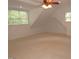 Spacious bonus room with plush carpeting, natural light, and a ceiling fan for a comfortable and versatile living space at 6673 Nc 96 W Hwy, Youngsville, NC 27596