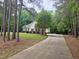 Inviting single-story home showcasing a concrete driveway and brick accents, surrounded by mature trees and landscaping at 6673 Nc 96 W Hwy, Youngsville, NC 27596