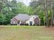 Inviting single-story home with well-maintained landscaping, brick accents, and a serene setting surrounded by mature trees at 6673 Nc 96 W Hwy, Youngsville, NC 27596