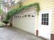 Attached garage with lush greenery offering curb appeal at 6673 Nc 96 W Hwy, Youngsville, NC 27596