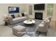 Staged living room featuring neutral furniture, fireplace, and large-screen television at 6673 Nc 96 W Hwy, Youngsville, NC 27596