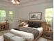 Staged bedroom with a king bed, natural lighting, and calming artwork at 6673 Nc 96 W Hwy, Youngsville, NC 27596