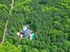 Aerial shot displays a property surrounded by dense woods, with a pool and long driveway at 754 Olde Thompson Creek Ct Rd, Apex, NC 27523