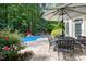 Outdoor living space featuring a pool, dining area, and a lush green backdrop at 754 Olde Thompson Creek Ct Rd, Apex, NC 27523