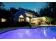 Back of house with in-ground pool, illuminated windows, outdoor dining set and screened in porch at 754 Olde Thompson Creek Ct Rd, Apex, NC 27523
