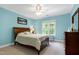 Inviting bedroom with light blue walls, a ceiling fan, and a large window offering plenty of natural light at 754 Olde Thompson Creek Ct Rd, Apex, NC 27523