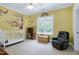 A bright Bedroom with Winnie the Pooh decals, a crib, a rocking chair, and natural light at 754 Olde Thompson Creek Ct Rd, Apex, NC 27523