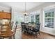 Bright dining area with large windows, hardwood floors, and stylish black chairs at 754 Olde Thompson Creek Ct Rd, Apex, NC 27523